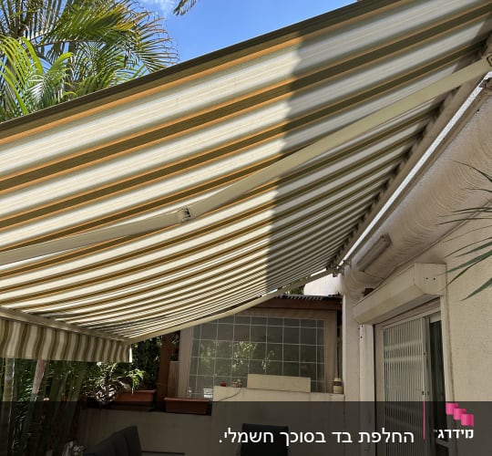 סוכך פסים מעל פינת ישיבה בחצר
